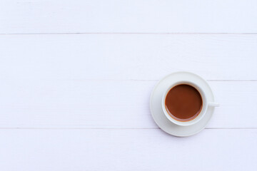 Top view image of a hot latte coffee in a white cup On a white wooden table with copy spcae