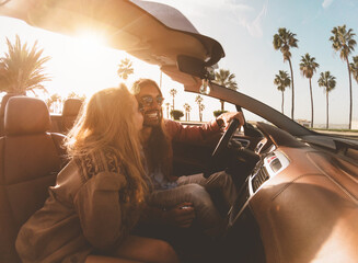 Happy young couple doing road trip in tropical city - Travel people having fun driving in trendy...