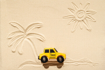 Toy taxi car, sun, palm tree on beach sand. Concept. Fast and cheap taxi booking service. Travel. Summer time. Creative