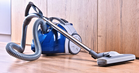 Canister vacuum cleaner for home use on the floor panels