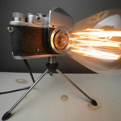 Retro lamp from an old camera with an Edison lamp on a gray background. Concept is a good idea.