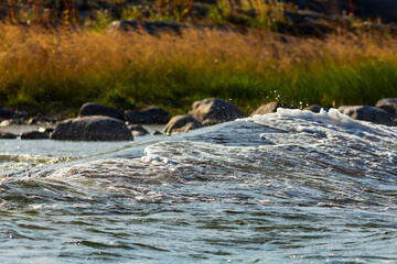 Fototapeta premium Water flowing over rocks by the shore