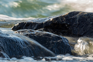 Water flowing over rocks by the shore