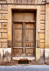 Obraz na płótnie Canvas Old wooden front door in Rome Italy weathered stone building Latin style character age decay history entrance authentic rustic Italian Roman porta 