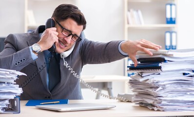 Desperate sad employee tired at his desk in call center