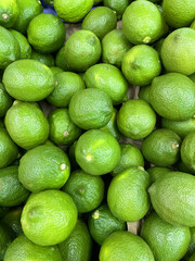 Green lime citrus fruits in market. Lime background.