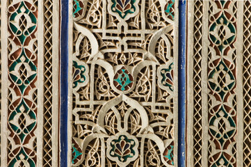 Detail of colorful decorative ceramic tiles in a door arch of the Bahia Palace in Marrakesh, Morocco. 
Focus on the flower in the center of the photo