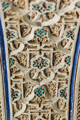 Detail of colorful decorative ceramic tiles in a door arch of the Bahia Palace in Marrakesh, Morocco. 
Focus on the flower in the center of the photo