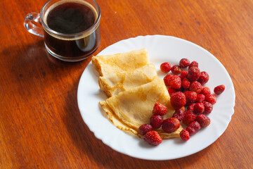 Breakfast on the table, pancakes with berries and coffee on the table