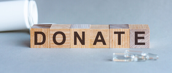 Donate text on a wooden background. Concept medicine.