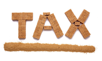 Cubes of brown sugar with grains of brown sugar underlining the word tax on a plain white background 