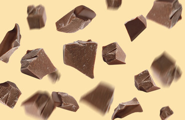Delicious chocolate pieces falling on yellow background