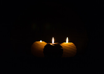 Three round candles in the dark