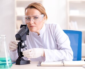 Woman chemist working in hospital clinic lab