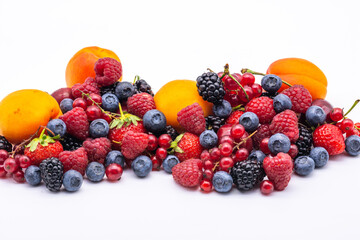 heap of assorted delicious summer fruits on white background