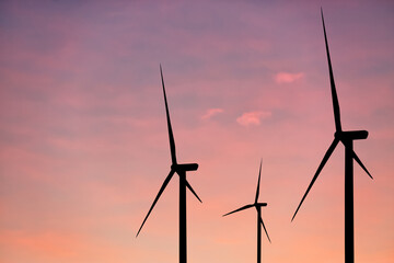 Silhouettes of wind turbines at sunset. Alternative energy source