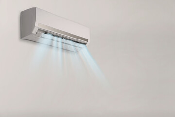 Modern air conditioner on light wall indoors