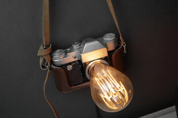 Retro lamp from an old camera with an Edison lamp on a gray background. Concept is a good idea.