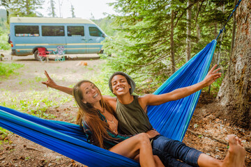 Lesbian couple in hammock out camping - Powered by Adobe