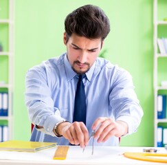 Young male architect working at the project