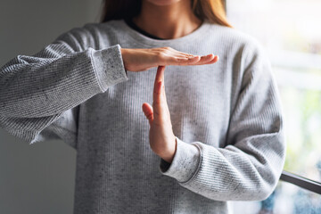 Closeup image of a woman making time out hand sign