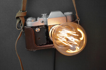 Retro lamp from an old camera with an Edison lamp on a gray background. Concept is a good idea.