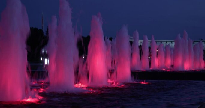 red fountains with backlight, large in the dark, 4k