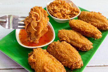 fried chicken in green plate on white wooden table