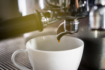 close up picture of coffee maker machine brewing expresso into a cup in the restaurant. barista and...