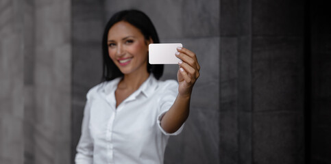Fototapeta premium Business Card Mockup Image. a Smiling Mixed Races Business Woman showing a Blank White Card
