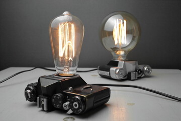 Retro lamp from an old camera with an Edison lamp on a gray background. Concept is a good idea.