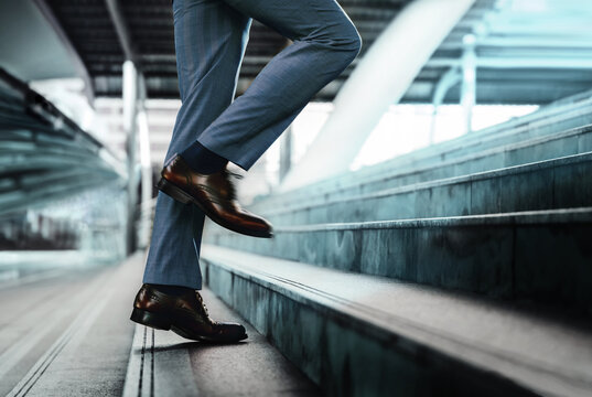 Motivation And Challenging Concept. Steps Forward Into A Success. Low Section Of Businessman Walking Up On Staircase