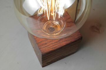 Retro wood lamp with Edison lamp on a gray background. The concept is a good idea.