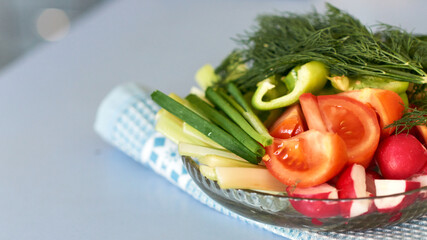Mix salad from fresh vegetables and greens herbs on the blue napkin. Dietary menu. Proper nutrition. Healthy lifestyle. Banner with copy space.