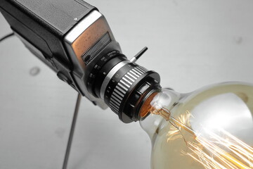 Retro lamp from an old camera with an Edison lamp on a gray background. Concept is a good idea.