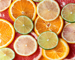 Obraz premium Beautiful fresh sliced mixed citrus fruits like background. Concept of healthy eating, detox, diet. Top view.