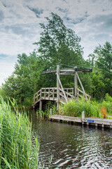 Fototapeta na wymiar old wooden drawbridge in the reed beds in Giethoorn, Netherlands