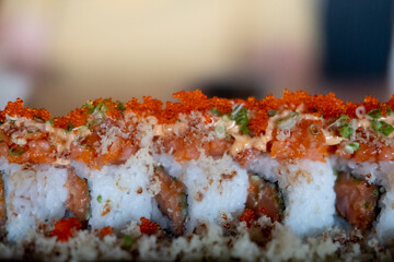 California roll topped with fresh salmon and salmon roe. Selective focus