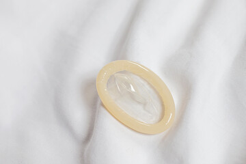 Condoms are ready to be used on white bedding.