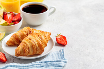 Breakfast croissants with coffee, juice and fruit, copy space.