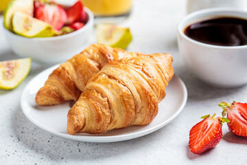 Breakfast croissants with coffee, juice and fruit.