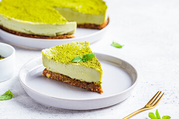 Piece of raw vegan matcha cake on a gray plate.
