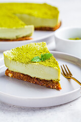 Piece of raw vegan matcha cake on a gray plate.