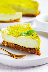 Piece of raw vegan matcha cheesecake on a gray plate.