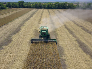 Harvesting of wheat in summer. Harvesters working in the field. Combine harvester agricultural...