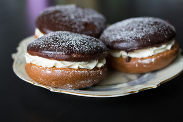 Boucher cakes with chocolate icing on a beautiful white shaped plate.