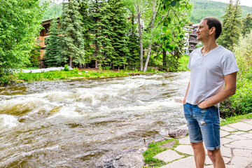 Man tourist standing looking at view in Vail, Colorado, USA European style resort town by Gore...