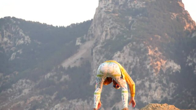 Young bald slender freak man in tight leggings, gold jacket, bandage on his head, dancing on roof, abnormal crazy, jumping, grimacing, showing ass, teasing. Slow motion video. Humor, unusual people