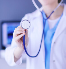 Close-up shot of doctor's hands holding stethoscope at clinic.