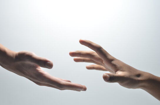 Two male hands reaching towards each other on isolated white background